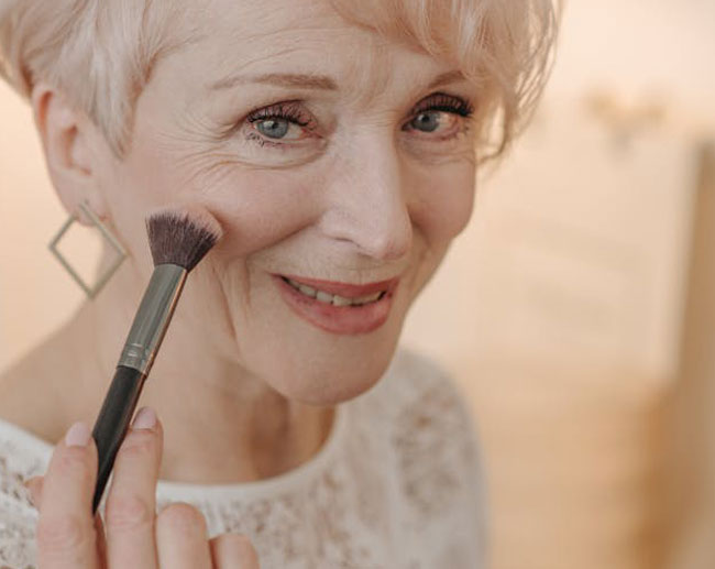 Rostro de mujer adulta con brocha de Maquillaje