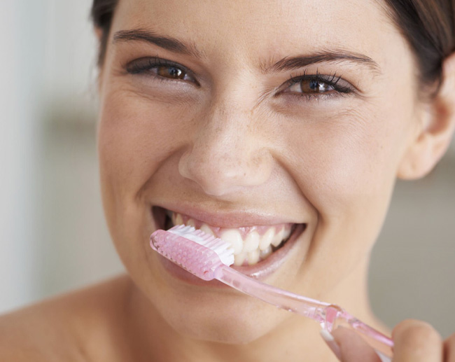 Mujer cepillandose los dientes